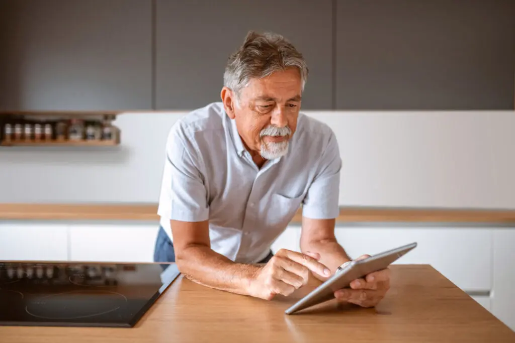 Man reviewing his medication list on a tablet.