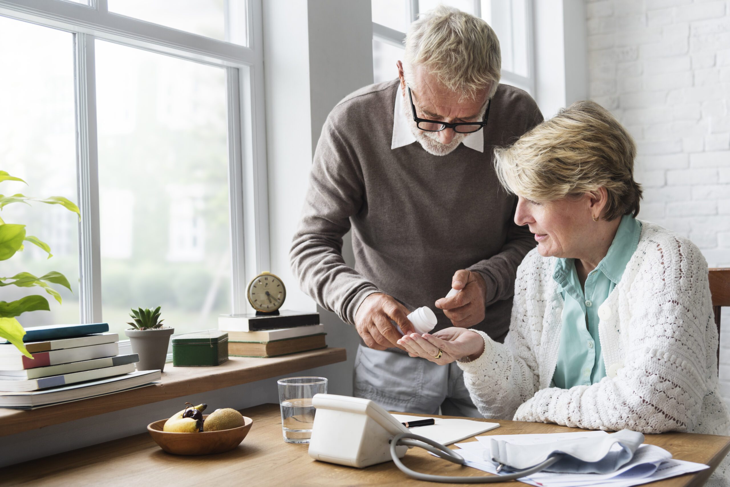 Senior adult man helping women pour medications