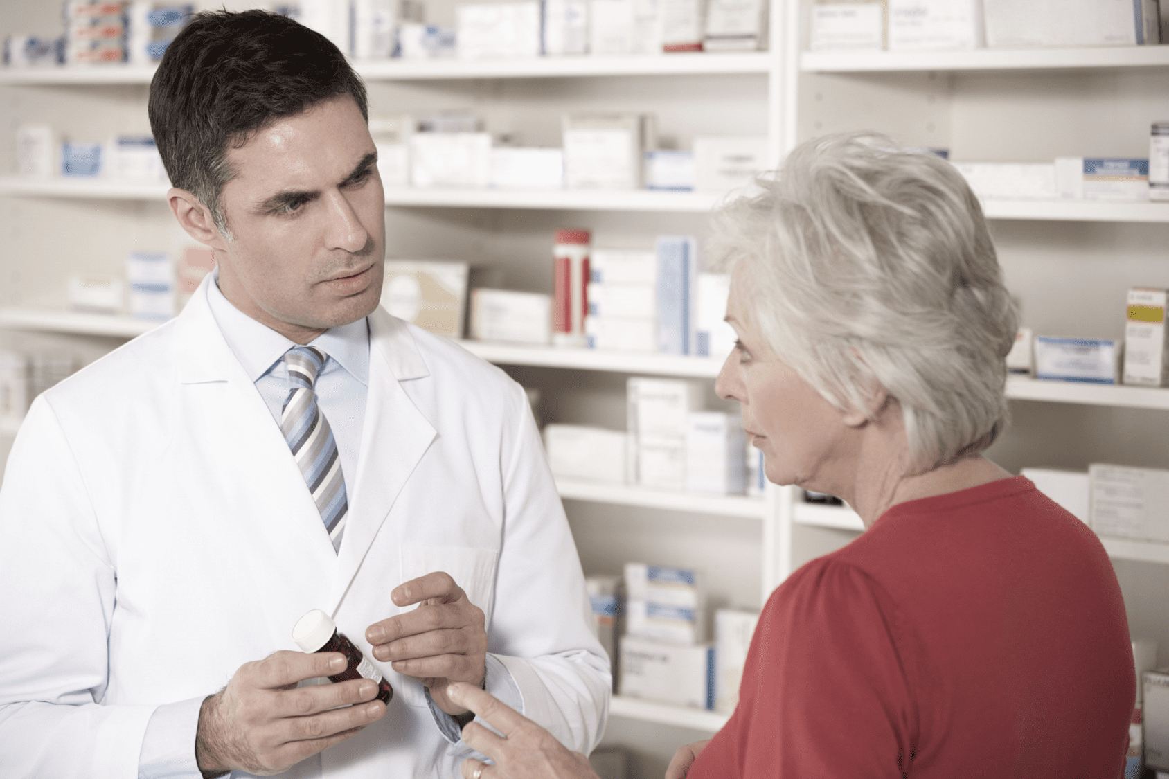 Pharmacist talks to older woman about prescription