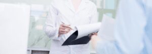 clinician holding clipboard in white lab coat