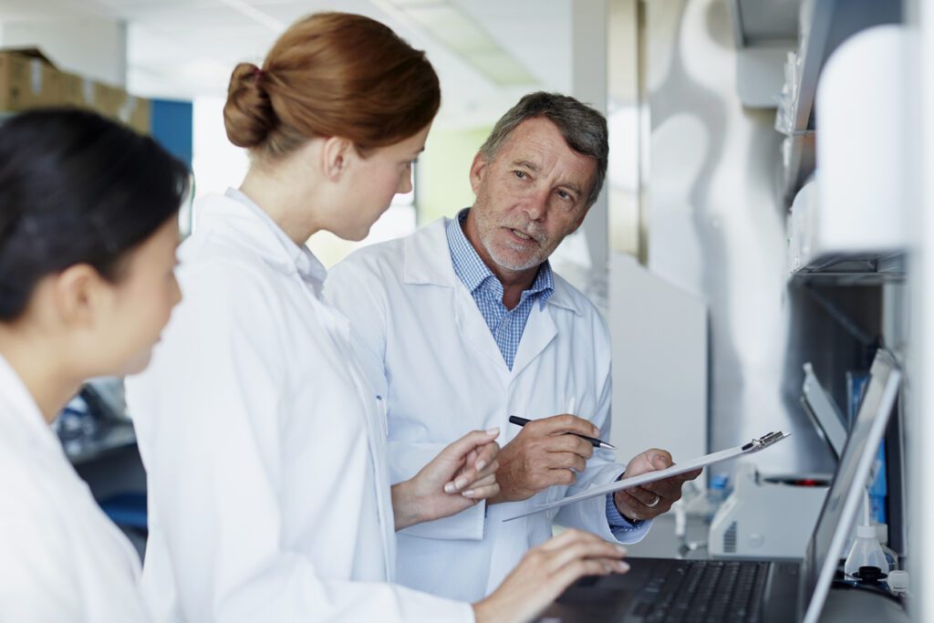 Research team discussing results on computer in modern laboratory